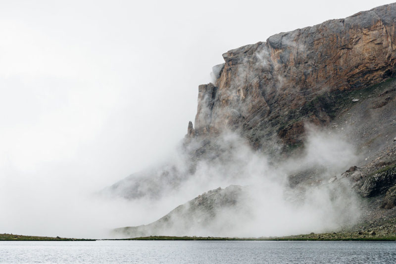 Облака вокруг скал у горного озера