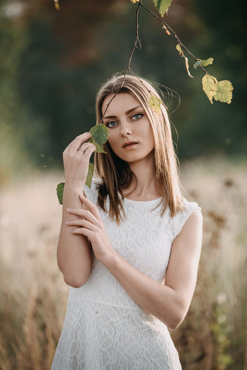 девушка касается ветки берёзы, осенняя фотосессия на природе