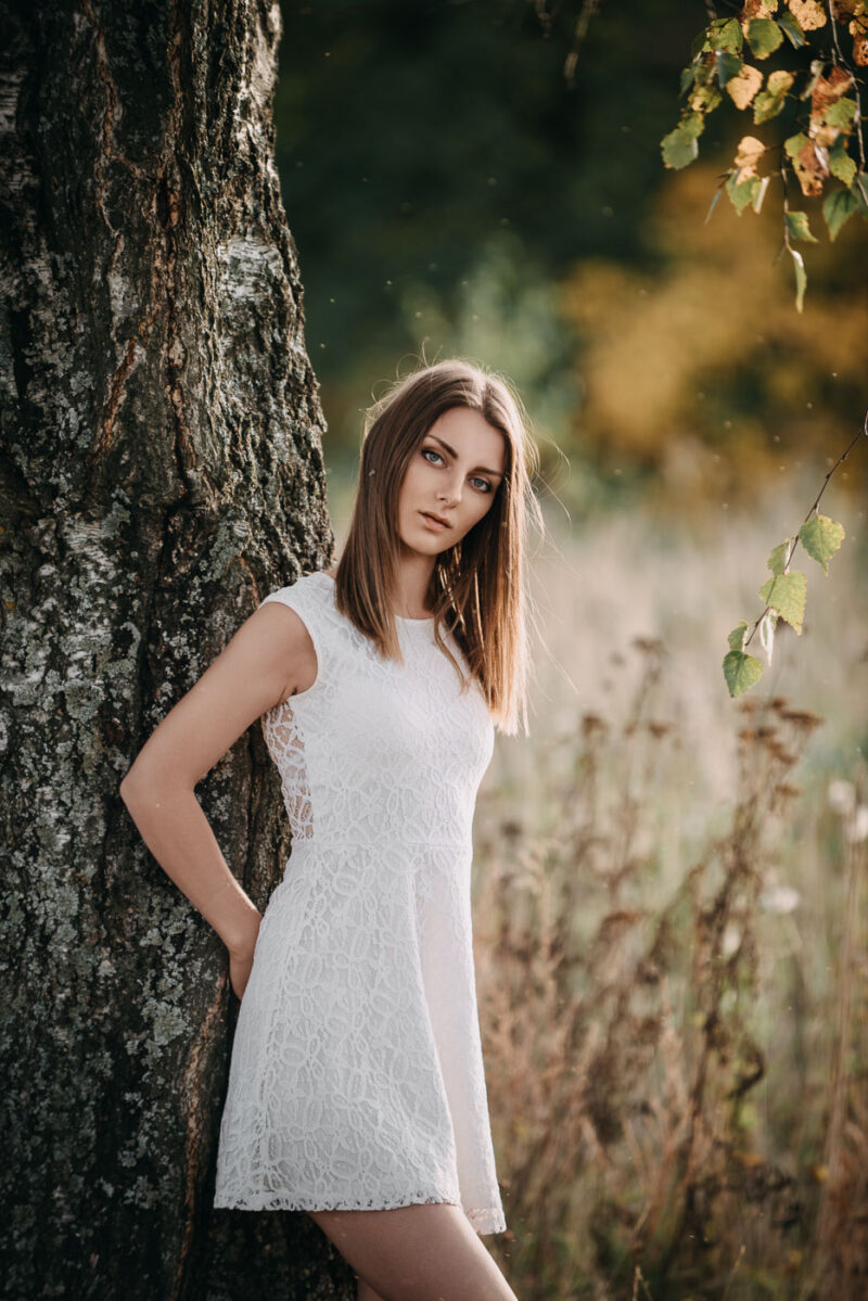 фотосессия на природе - девушка стоит у дерева в тёплый осенний день