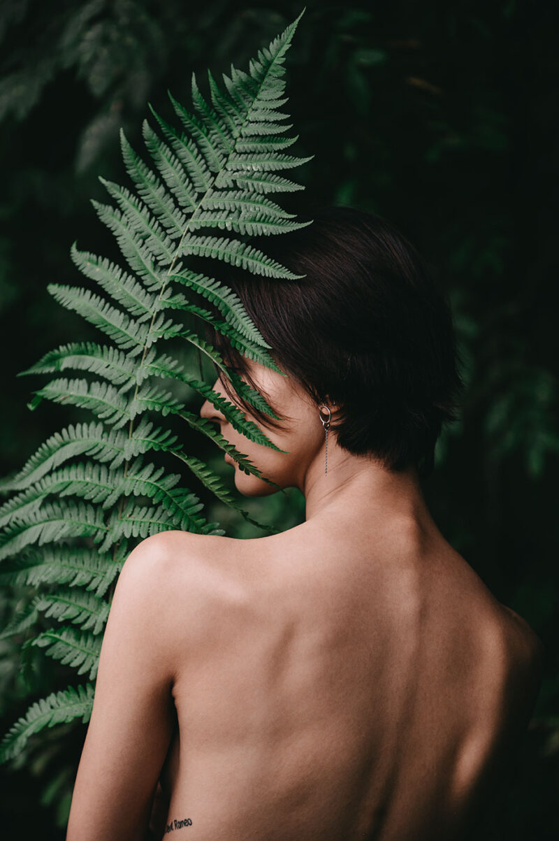 Обнажённая фигура с папоротником среди зелени