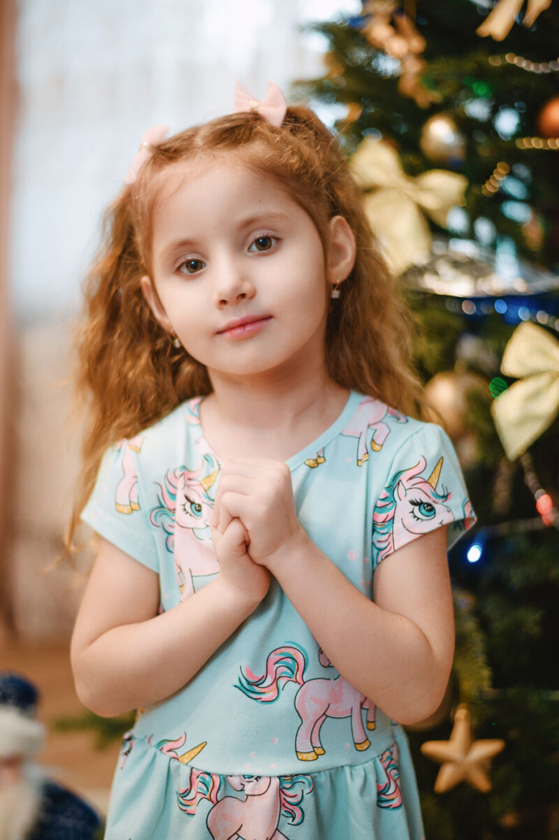 Семейная фотосессия дома в Ярославле - девочка стоит у новогодней ёлки в квартире