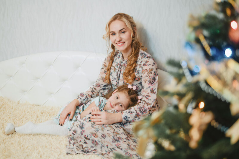 Семейный портрет на диване - девочка лежит на коленях у мамы