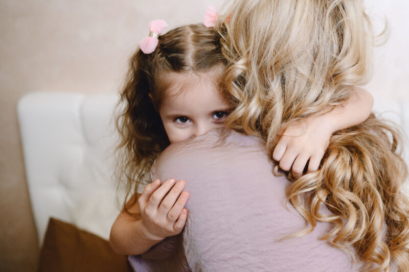 Крупный план дочки, обнимающей маму на домашней фотосессии