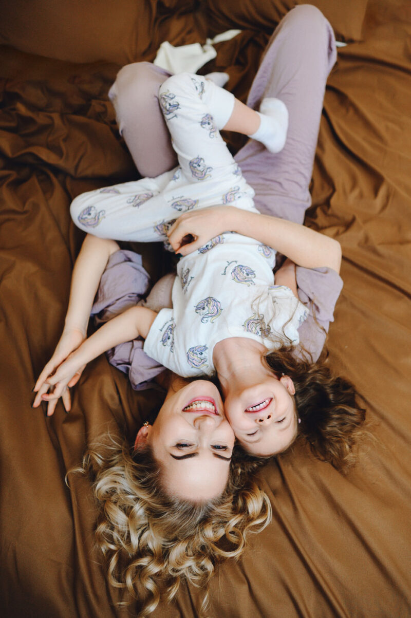 Семейная съёмка в ярославской квартире - мама и дочка лежат на кровати и улыбаются