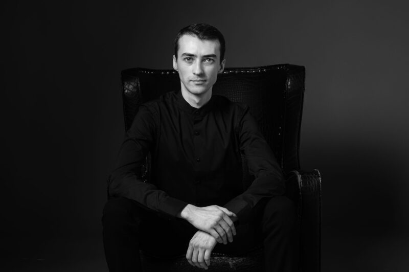 Мужская фотосессия в Ярославле - мужчина в кожаном кресле на тёмном фоне, чёрно-белый кадр