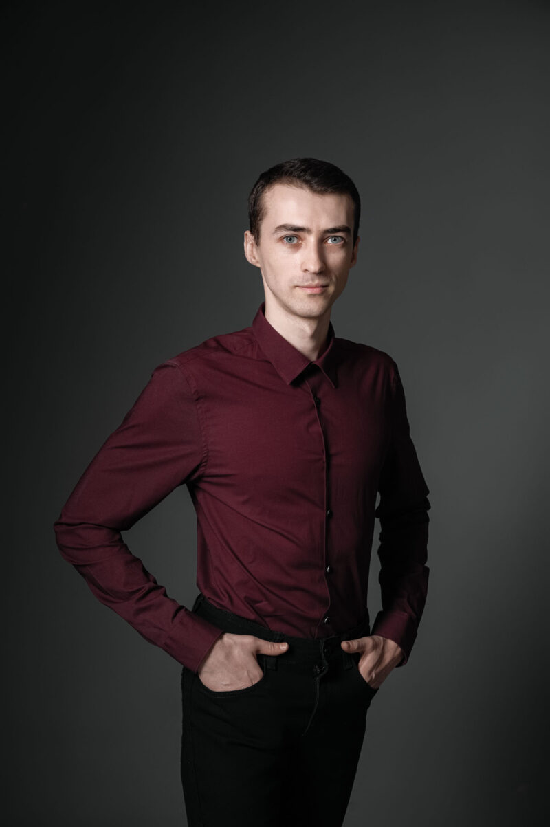 Мужской портрет по пояс в тёмной фотостудии Ярославля, руки в карманах, чёрно-белое фото