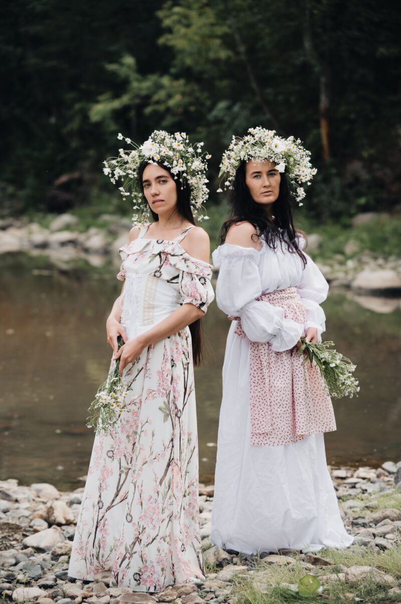 две девушки в образе лесных нимф на фоне лесной реки