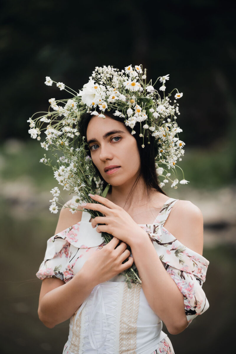художественный портрет девушки крупным планом с венком на голове и с букетом полевых цветов