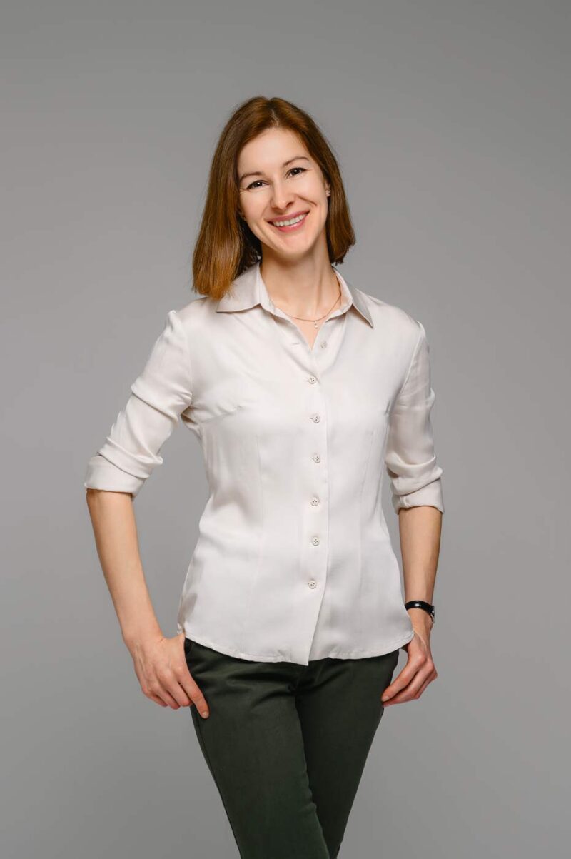 Улыбающаяся девушка позирует на светлом фоне