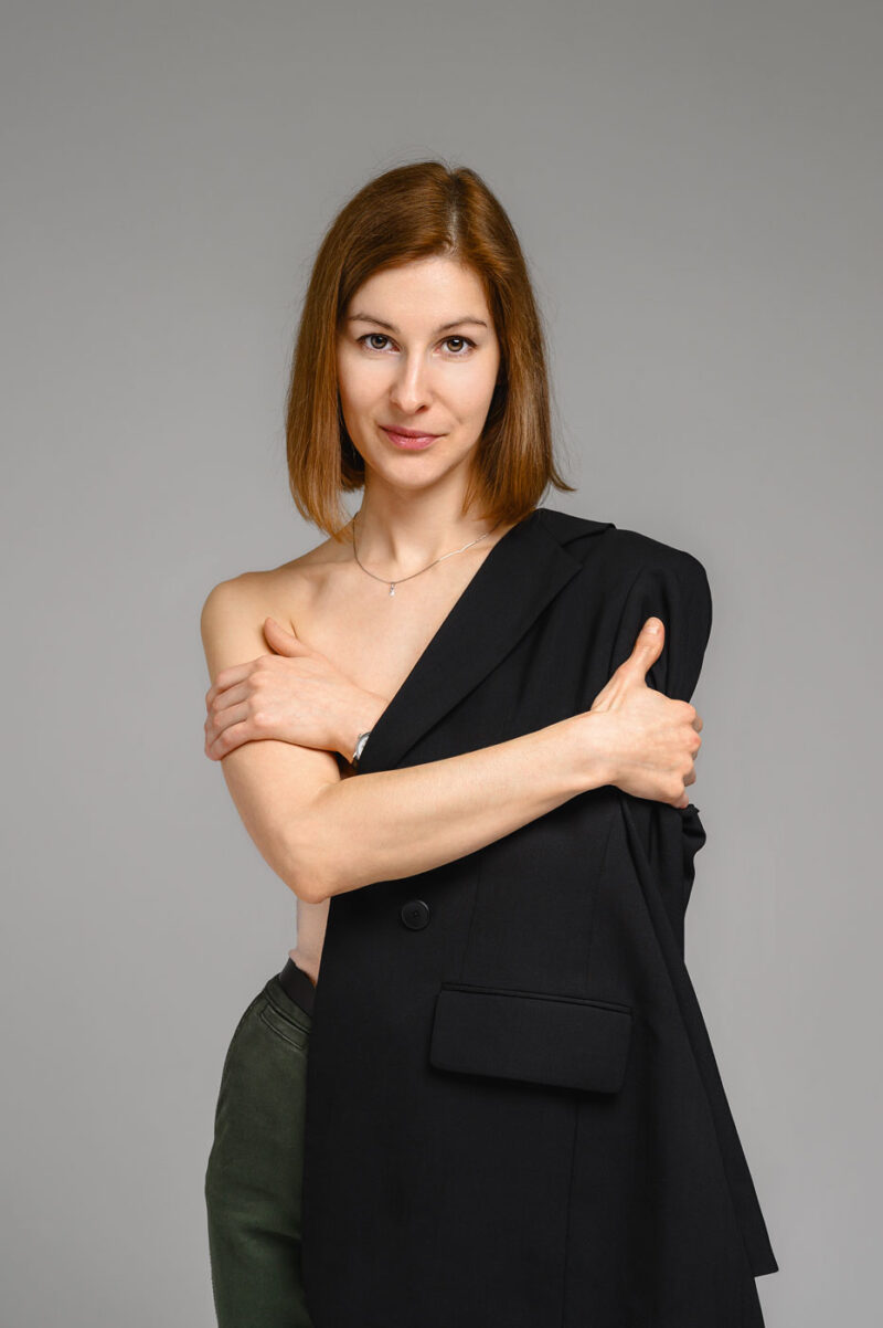 Полуобнаженная девушка прикрывается черным пиджаком