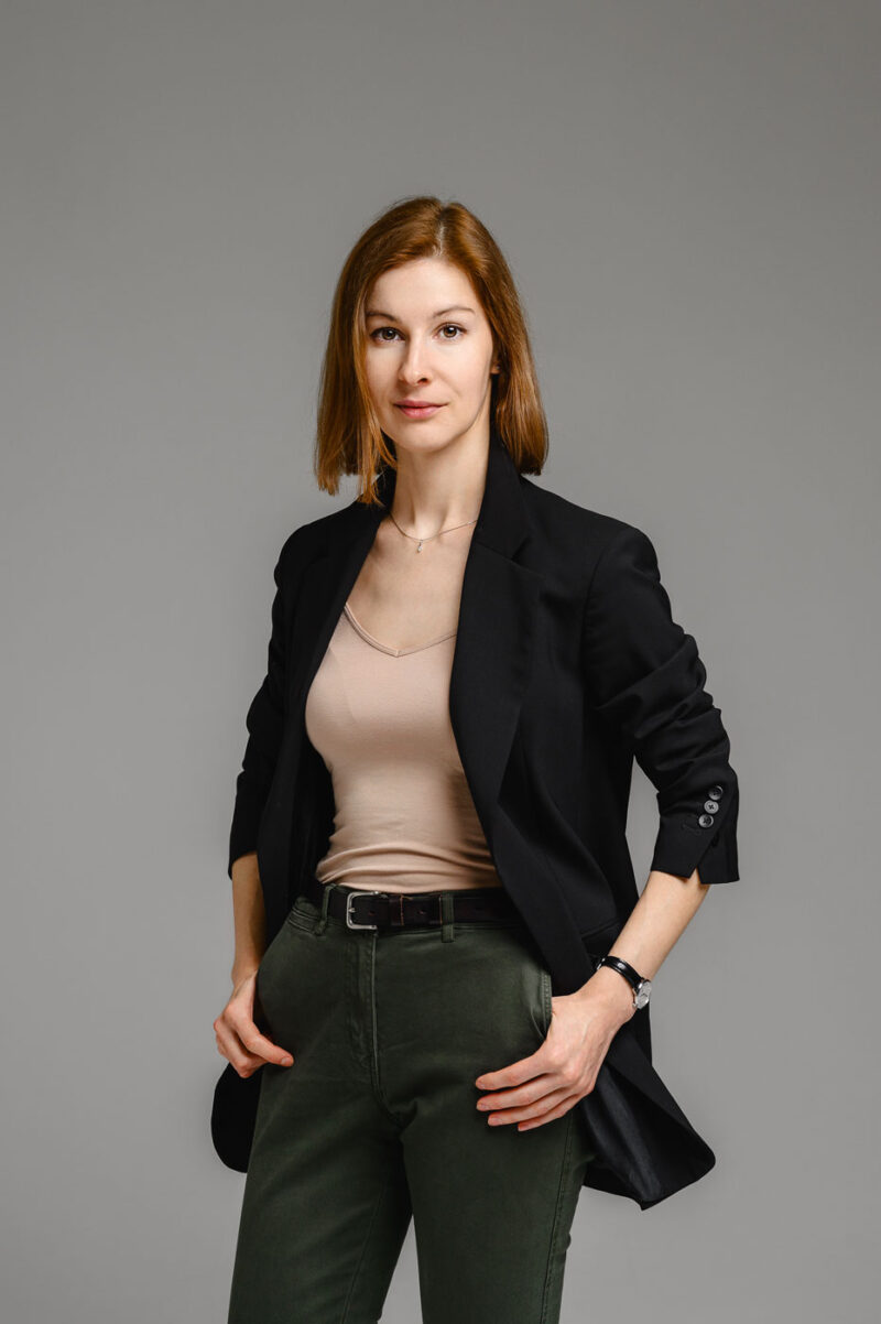 Девушка держит руки в карманах брюк на фотосессии в студии