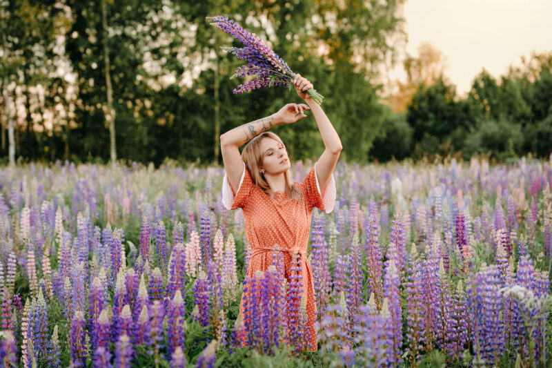 Девушка на природе с поднятым над головой букетом