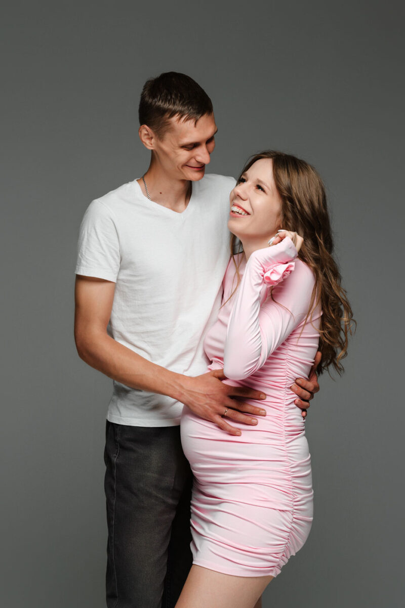 минималистичный студийный портрет мужа и беременной жены