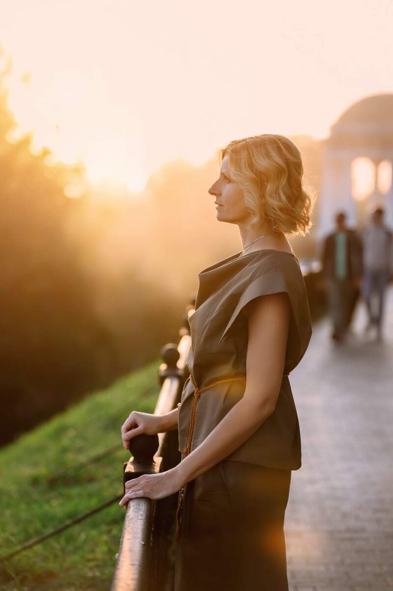 Атмосферный женский портрет во время золотого часа на Стрелке в Ярославле, мягкий закатный свет, солнце в кадре