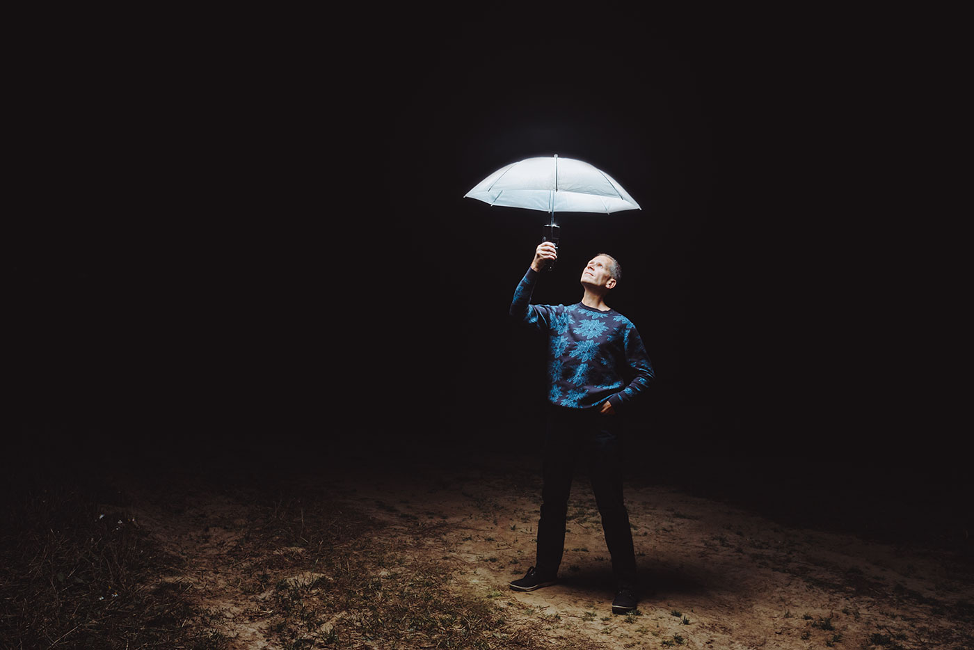 Автопортрет фотографа: человек со светящимся зонтом в ночном поле как символ творческой свободы и поиска своего пути