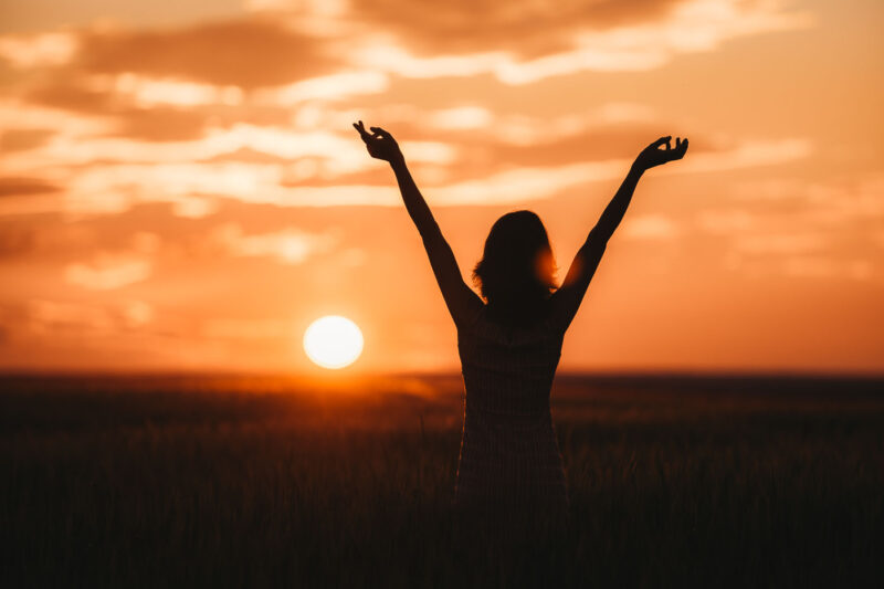 силуэт девушки в поле на закате